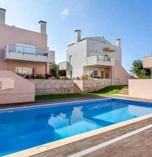 a house with a swimming pool in front of a house at Casa Aromas do Mar, Burgau in Burgau