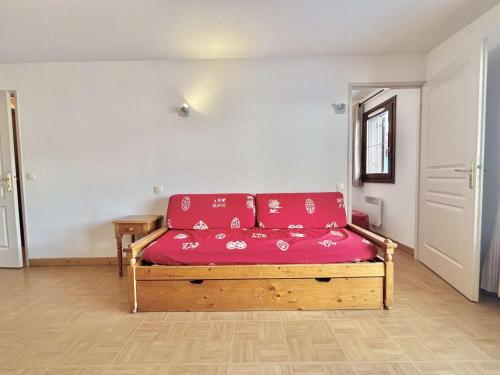 - un canapé avec des coussins rouges dans l'établissement Appartement 6 pers. à Flumet avec piscine, parking et animaux admis - FR-1-603-114, à Flumet
