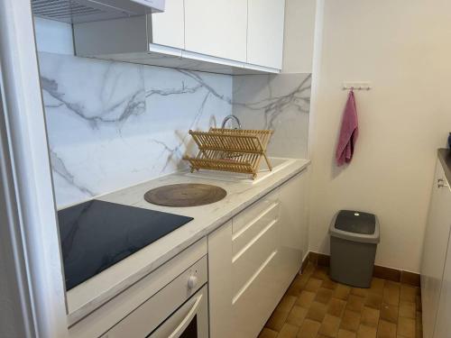 - une cuisine avec des comptoirs en marbre blanc et un évier dans l'établissement T2 Cabine au Lavandou - Vue Mer, Parking Privé - FR-1-251-858, au Lavandou