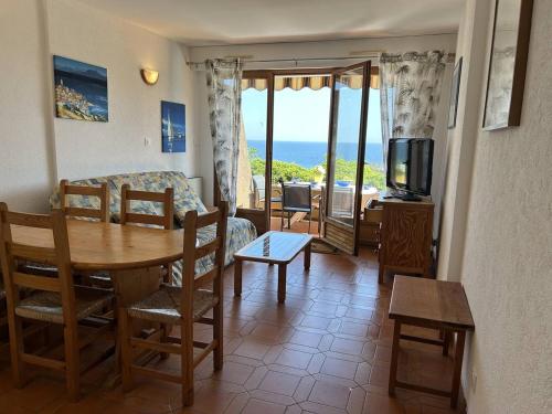 - un salon avec une table, un canapé et une télévision dans l'établissement T2 Cabine au Lavandou - Vue Mer, Parking Privé - FR-1-251-858, au Lavandou