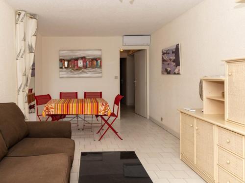 un salon avec une table et des chaises rouges dans l'établissement T2 au Lavandou: 4 pers, face mer, terrasse, plage à 1 min, parking privé - FR-1-803-38, au Lavandou