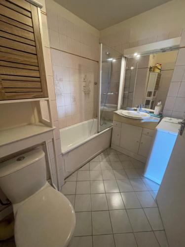 a bathroom with a toilet and a tub and a sink at Proche Chartres et Colisée in Mainvilliers