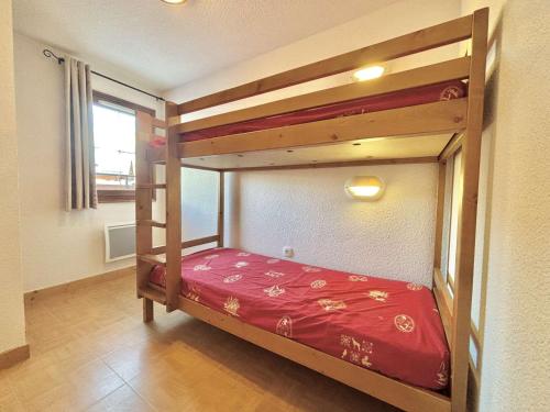 une chambre avec un lit superposé avec un couvre-lit rouge dans l'établissement Appartement 3 pièces à Flumet - 6 pers, Piscine, Parking - FR-1-603-115, à Flumet