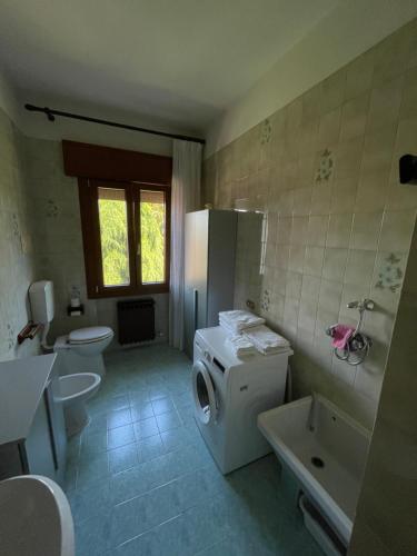a bathroom with a refrigerator and a washer and dryer at Country House la Quercia in Mogliano Veneto