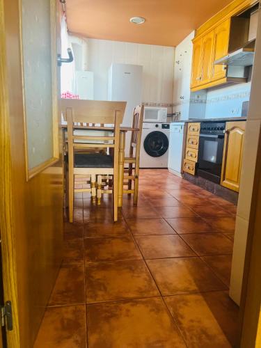 a kitchen with a table and chairs on a tile floor at Apartamento completo in Burriana