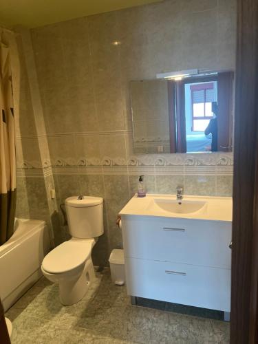 a bathroom with a toilet and a sink and a mirror at Apartamento completo in Burriana