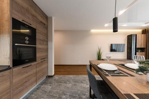 a kitchen and dining room with a wooden table and chairs at Luxury Apartments Babyak in Uzhhorod