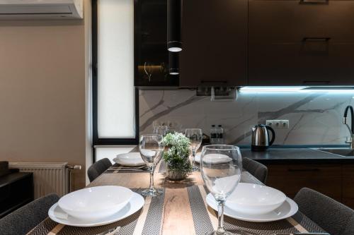 a table with plates and wine glasses on it at Luxury Apartments Babyak in Uzhhorod