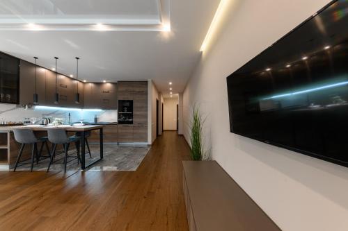 a kitchen and dining room with a large television on the wall at Luxury Apartments Babyak in Uzhhorod