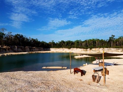 a tent on a beach with a body of water at Camping Kitam in Tulum