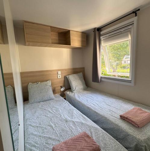 une petite chambre avec deux lits et une fenêtre dans l'établissement Bungalow 410, 8 pers Camping 4 étoiles Siblu Le Lac des Rêves, à Lattes
