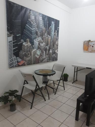 a table and chairs in a room with a painting on the wall at Frente aeropuerto de Isla Verde in San Juan