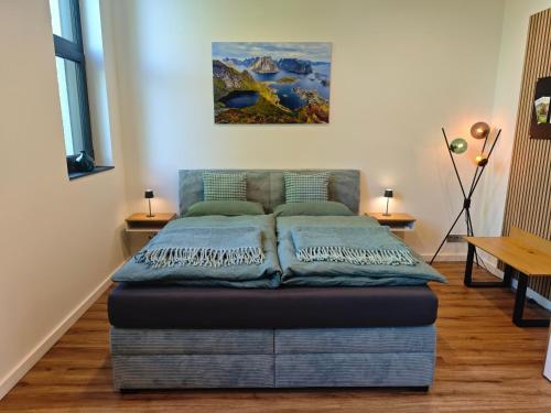 a bed in a room with a painting on the wall at Nordloft Bad Nenndorf in Bad Nenndorf