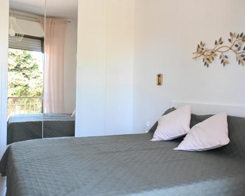 a bedroom with a bed with two pillows and a window at PP07 - Porto Potenza, trilocale vista mare con aria condizionata in Porto Potenza Picena