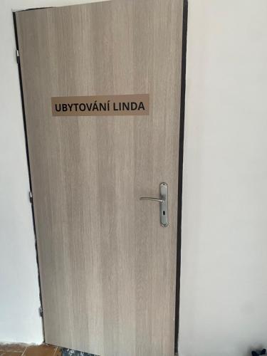 a wooden door with a sign on it at Ubytování Linda in Klášter Hradiště nad Jizerou