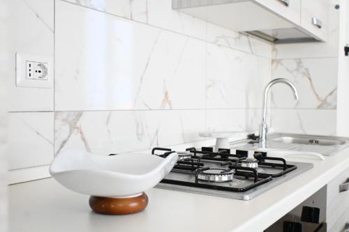 a white kitchen with a sink and a stove at PP07 - Porto Potenza, trilocale vista mare con aria condizionata in Porto Potenza Picena