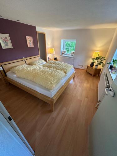 a bedroom with a large bed and a wooden floor at FeWo "Luna Meadow" im RausHaus Heed in Meinerzhagen