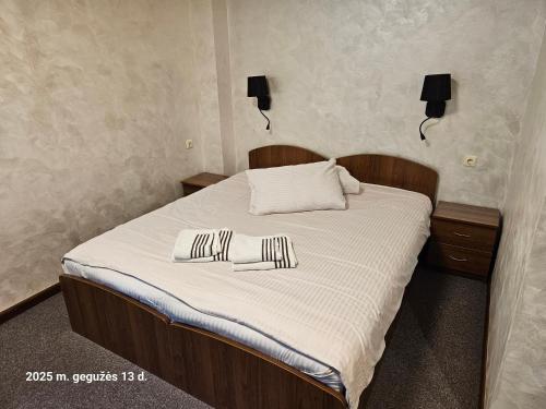 a bedroom with a bed with two pillows on it at Pas Nerijų in Skuodas