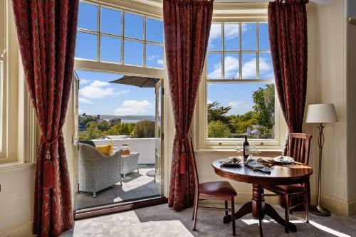 a living room with a table and a large window at Vomero Holiday Apartments in Torquay