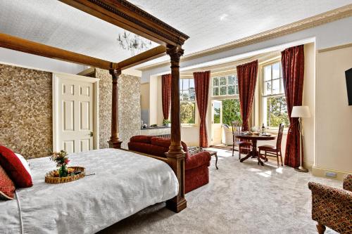 a bedroom with a canopy bed and a living room at Vomero Holiday Apartments in Torquay