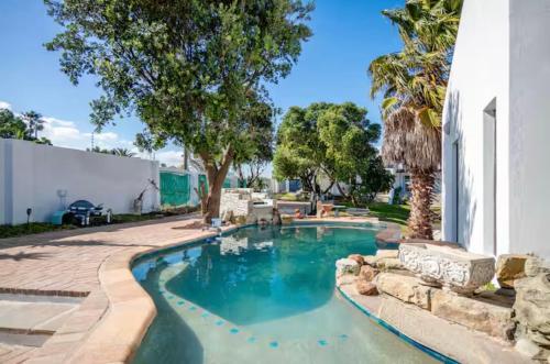 a swimming pool in a yard with trees and a building at Spearhead on Lake Accommodation-5A in Marina da Gama