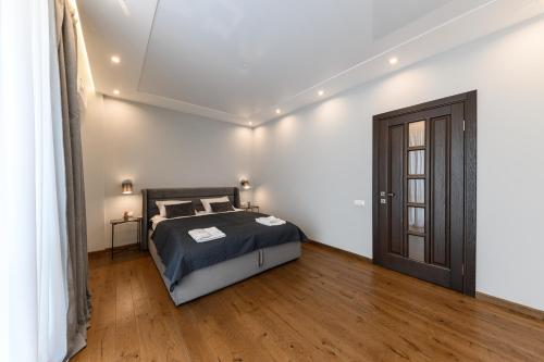a bedroom with a bed and a wooden floor at Luxury Apartments Babyak in Uzhhorod