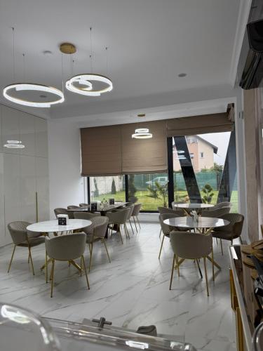 a dining room with tables and chairs and a large window at Galactic&Ludmila Suite SPA in Braşov
