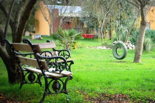 two park benches sitting in a field of grass at Complejo Dulcería El Cazador y cabañas in Tandil