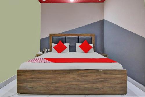 a bedroom with a bed with red pillows at Super Hotel O Green Villa in New Delhi