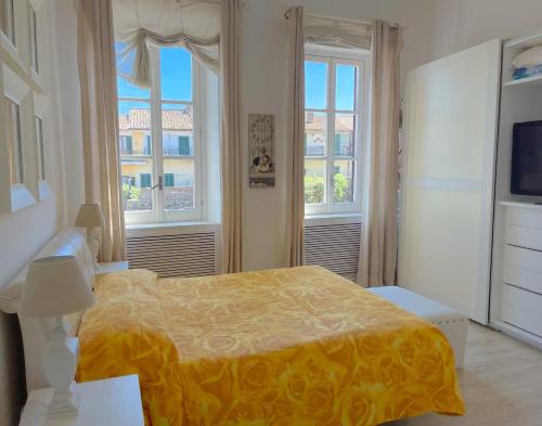 a bedroom with a bed and two windows at LUNA SUL PORTO Seaview Apartment - Bright and Spacious Flat in Central Nettuno, Steps from the Marina, Beaches, and Train Station in Nettuno