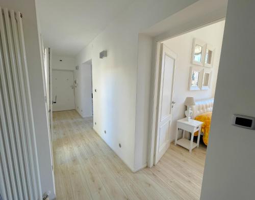 an empty white room with a bed and a table at LUNA SUL PORTO Seaview Apartment - Bright and Spacious Flat in Central Nettuno, Steps from the Marina, Beaches, and Train Station in Nettuno