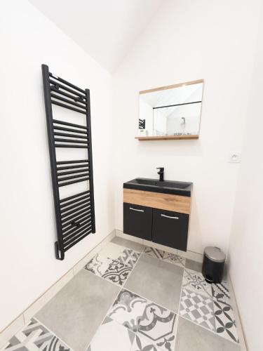 une salle de bain avec un lavabo et un miroir dans l'établissement L Atelier cocon douillet, à Nogentel