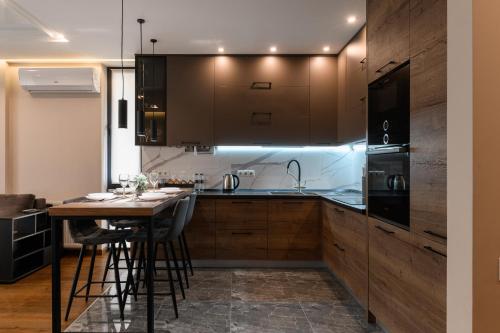 a kitchen with wooden cabinets and a table with chairs at Luxury Apartments Babyak in Uzhhorod