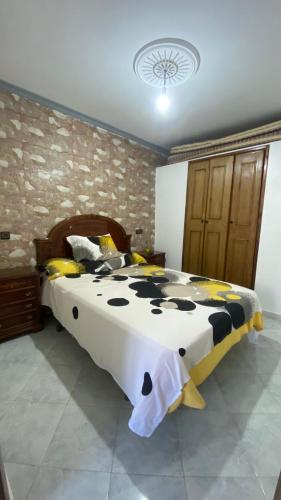 a bedroom with a bed with a black and white comforter at Chefchaouen in Chefchaouene