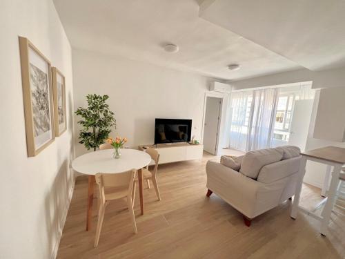 una sala de estar con una mesa y un sofá en Sol, centro y playa, en Almería