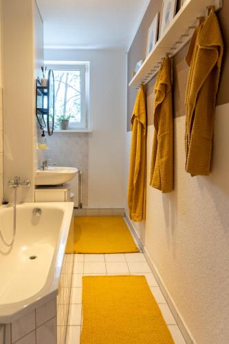 a bathroom with yellow rugs and a sink at Ferienwohnung für den Perfekten Work-Life-Ausgleich in Spremberg