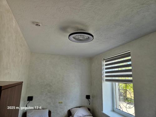 a ceiling with a light in a room with a window at Pas Nerijų in Skuodas