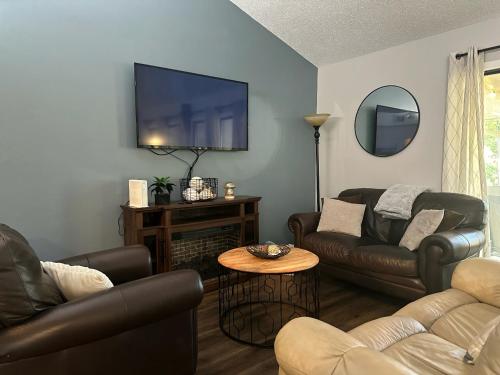 a living room with leather furniture and a flat screen tv at No Putts Given. Cozy home on Par 4, free Golf Cart and Pool access in Osage Beach