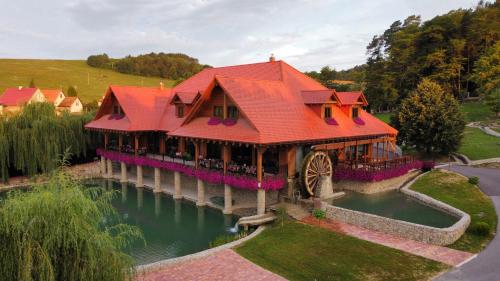 a house with an orange roof on a lake at Kúpeľný mlyn Bojnice in Bojnice