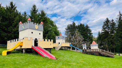 a playground with a castle and slides in a field at Kúpeľný mlyn Bojnice in Bojnice