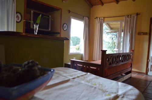 a room with a table and a chair and a window at Complejo Dulcería El Cazador y cabañas in Tandil