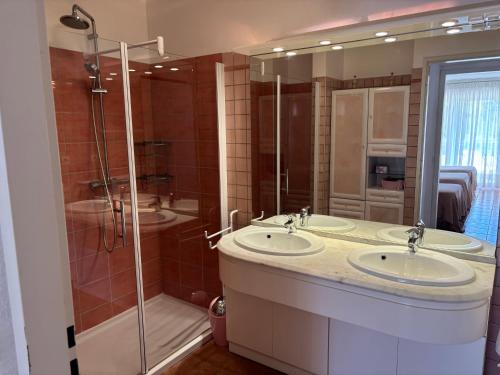 a bathroom with two sinks and a shower at RESIDENCE LES TERRASSES in Calvi