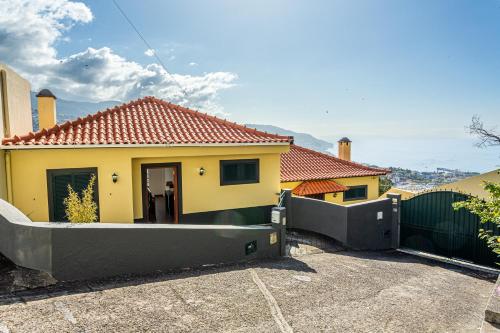 ein gelbes Haus mit einem Tor und einem Zaun in der Unterkunft Casa Barcelos View in Funchal