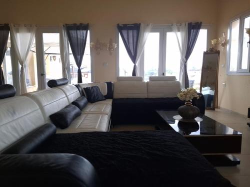 a living room with a white couch and a table at Golden House in Kidmat Tsvi