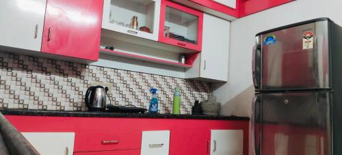 a kitchen with red cabinets and a red refrigerator at Hillview Homestay in Tiruvannāmalai