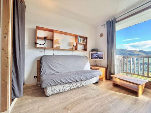 une chambre avec un lit et une grande fenêtre dans l'établissement Studio confortable à Notre-Dame-de-Bellecombe avec parking et accès facile aux pistes - FR-1-595-35, à Notre-Dame-de-Bellecombe