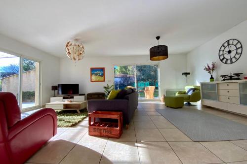 a living room with a couch and chairs and a clock at Le Clos St Roch- Family home in Montpellier! in Montpellier