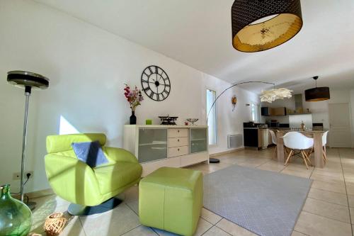 a living room with a green chair and a table at Le Clos St Roch- Family home in Montpellier! in Montpellier