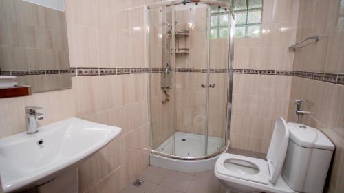 une salle de bains avec douche, toilettes et lavabo dans l'établissement Royal Heritage Resort, à Kandy