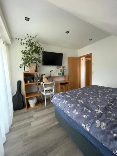 a bedroom with a bed and a desk with a computer at Gemütliches Haus im Herzen des Schwarzwaldes für bis zu 9 Personen in Elzach